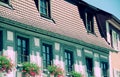 Well-kept building with mansard roof and row of windows with floral decorations Royalty Free Stock Photo