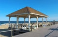 Well-kept pavilion with benches on boardwalk in front of beach (sand and shore) Royalty Free Stock Photo