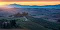 Well known Tuscany landscape with grain fields, cypress trees and houses on the hills at sunset. Summer rural landscape with Royalty Free Stock Photo