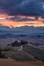 Well known Tuscany landscape with grain fields, cypress trees and houses on the hills at sunset. Summer rural landscape with Royalty Free Stock Photo