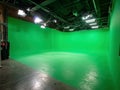 Well-lit green screen studio for video production Green floor, walls, and set design elements Multiple ceiling lights create Royalty Free Stock Photo