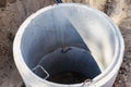 A well made of reinforced concrete rings with water at the bottom. Inside the well. Sewer well from the inside