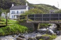 A well maintained detached house and garden with a river passing under a small bridge. Royalty Free Stock Photo