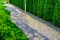 Well maintained formal garden with a paths of small stones, hedgerow and green lawn - in greenery tone Royalty Free Stock Photo