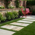 Lush garden with colorful plants, stone path, and red chairs for relaxation Royalty Free Stock Photo
