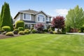 a well-manicured lawn next to a suburban two-story house