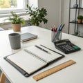Well-organized workspace featuring a notebook, pen, calculator, ruler, and plants on a desk Royalty Free Stock Photo