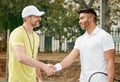 Well played. a handsome young male tennis player shaking hands with his coach outside on the court. Royalty Free Stock Photo