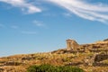 Well preserved Temple of Isis on Delos Island located on the hill above the ancient city with other ruins and blue sky