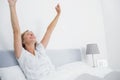 Well rested blonde woman stretching in bed and smiling Royalty Free Stock Photo