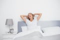 Well rested blonde woman stretching and yawning in bed Royalty Free Stock Photo