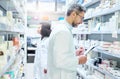 Well stocked to keep their customers well. a mature man doing inventory in a pharmacy with his colleague in the Royalty Free Stock Photo