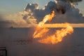 Well testing operation flaring of an oil and gas drilling rig. Burning huge gas flame controlled by the deluge system Royalty Free Stock Photo