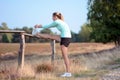 Well trained woman stretches muscles after jogging, running and exercising outdoors in nature Royalty Free Stock Photo