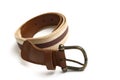 A well used coil of unisex style light and dark brown waist belt against a white backdrop