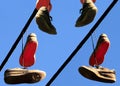 Well worn sport shoes hanging from power line Royalty Free Stock Photo