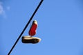 Well worn tennis shoes hanging from power line Royalty Free Stock Photo