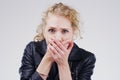 Well you dont see that everyday. Studio shot of a young woman looking shocked against a grey background.