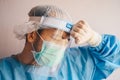 Doctor having headache and tired from work while wearing PPE suit for protect coronavirus disease. Royalty Free Stock Photo