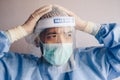 Doctor having headache and tired from work while wearing PPE suit for protect coronavirus disease. Royalty Free Stock Photo