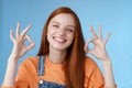 Wellbeing, happiness, perfection concept. Attractive friendly smiling joyful redhead female student show excellent okay