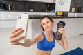 Wellbeing and sports. Beautiful young woman taking selfie on smartphone, doing fitness training from home, drink water Royalty Free Stock Photo