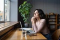 Wellbeing at work. Young dreamy female employee enjoying good window view while working in office