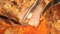 Welldone steak cut onto thin slices; closeup