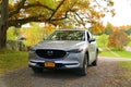 Wellesley Island, New York, U.S.A - October 25, 2019 - A silver Mazda CX-5 SUV surrounded by fall foliage