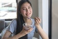 Close up young girl eating yogurt and nuts as breakfast  at home Royalty Free Stock Photo