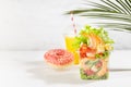 Wellness fresh summer food take away - set of orange juice, pink donut, tropical salad with shrimps, lettuce, red pepper, croutons Royalty Free Stock Photo