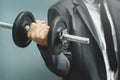 Wellness, healthy concepts. Businessman lifting dumbbell at office.