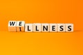 Wellness or illness symbol. Concept words Wellness and Illness on wooden cubes. Beautiful orange table orange background. Medicak Royalty Free Stock Photo