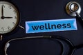 Wellness on the print paper with Healthcare Concept Inspiration. alarm clock, Black stethoscope.