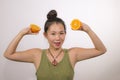 Wellness and self care - young happy and beautiful Asian Chinese woman holding orange fruit sliced in half smiling cheerful in Royalty Free Stock Photo