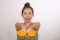 Wellness and self care - young happy and beautiful Asian Japanese woman holding orange fruit sliced in half smiling cheerful in Royalty Free Stock Photo