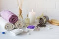 Wellness setting. Purple sea salt, towel, massage oil , lavender flowers and candle on white textured background. Royalty Free Stock Photo