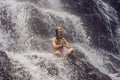 Wellness spa, vacation and yoga meditation concept. Young woman sitting in lotus position on the rock in tropical Royalty Free Stock Photo