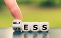 Wellness instead of stress. Hand turns a dice and changes the word `stress` to `wellness. Royalty Free Stock Photo