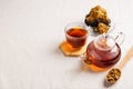 Wellness tea from chaga tree mushroom in a glass teapot and glass. Organic drink antioxidant gray natural background.