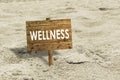 Wellness wooden sign on a beach.