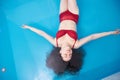 Wellness - young woman floating in Spa or swimming pool, she is very relaxed. Top view. Copy space. Royalty Free Stock Photo