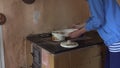 Wench woman take cooked dumplings from boiling pot on furnace stove. 4K