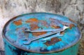 Wenches above a rusty light-blue barrel Royalty Free Stock Photo