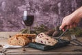 Wensleydale cheese with cranberries, red wine, honey, nuts, raisins on wooden cutting board. Black concrete background Royalty Free Stock Photo