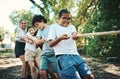 Were all winning when were playing together. Shot of a group of teenagers playing a game of tug of war at summer camp. Royalty Free Stock Photo