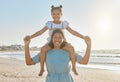 Were beach bums for sure. Portrait of a mother carrying her daughter on her shoulders at the beach. Royalty Free Stock Photo