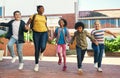 Were the best group of friends. Full length shot of a diverse group of children skipping outside during recess at school