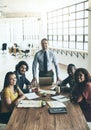 Were in the business of big ideas. Portrait of a team of smiling businesspeople gathered around a table in their office Royalty Free Stock Photo