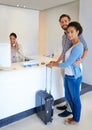 Were celebrating our honeymoon. Full length shot of a young couple checking in to a hotel. Royalty Free Stock Photo